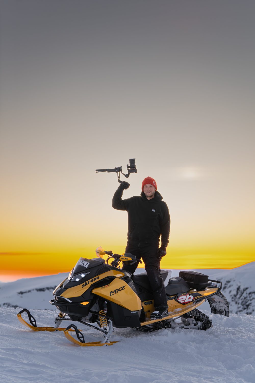 William Falkensson med kamera på sin Ski-Doo i fjällen vid solnedgång